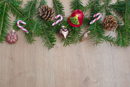 Christmas flat lay with pine branches, Christmas ornaments and pinecone on a wooden background