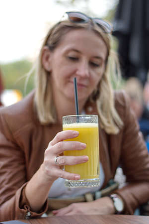 Portrait of the mature woman sitting in the restaurant drinking juice
