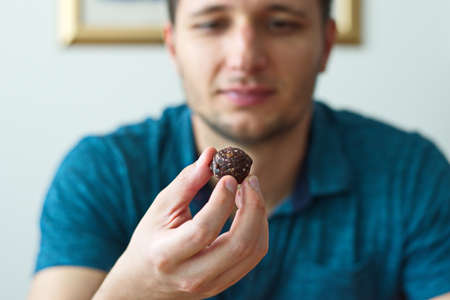 Bokeh portrait of young man holding cookieの写真素材