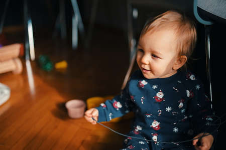 Cute little boy in Christmas costume siting on a floor and playing