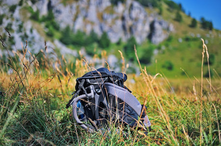 Closeup of backpack left on the grass in the valleyの写真素材