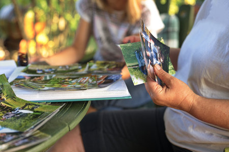 Female hands holding photo album while sitting in backyard