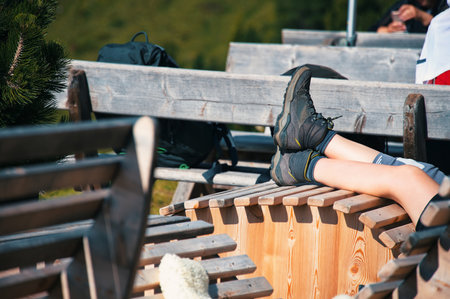 Hiker having rest on wooden chair of mountain hutの写真素材