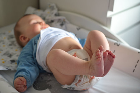 Cute little baby in diapers on the changing tableの写真素材