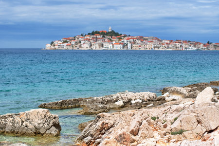 Rocky beach with cityscape of Mediterranean town in backgroundの写真素材