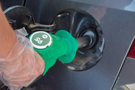 Man's hand filling petrol at station