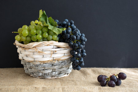 Ripe grapes in wicker basketの写真素材