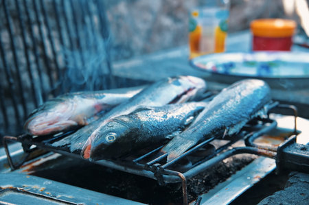 Closeup of grilling fish on gridironの写真素材