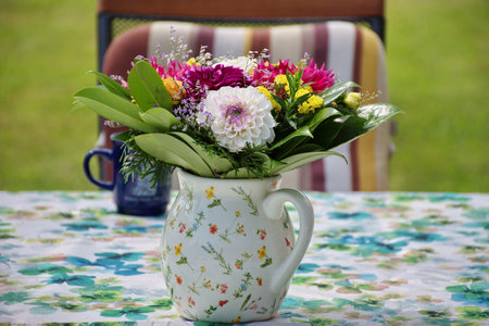 Colorful flowers in a vase on the table in backyard