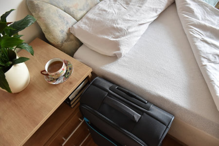 Above shot of bed, tea and luggage in bedroom