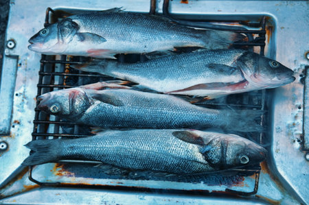 Flat lay of grilling fish on gridiron