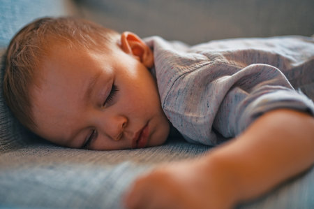 Closeup of cute little boy sleeping on couchの写真素材