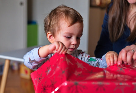 Toddler opening wrapped Christmas giftの写真素材