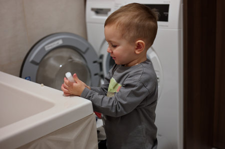 Portrait of cute little toddler playing in bathroomの写真素材