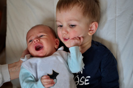 Cute little toddler and his newborn baby sisterの写真素材