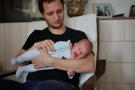 Portrait of man holding newborn baby girlの写真素材