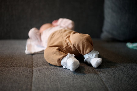Newborn baby girl lying on a sofa with her feet in foregroundの写真素材
