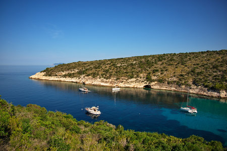Deep bay in Adriatic sea with sailboats anchored in clear blue waterの写真素材