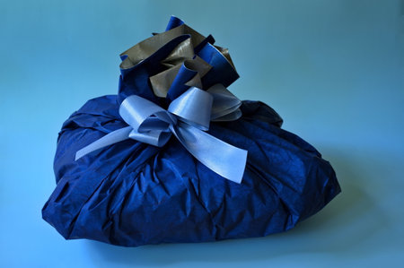 Gift wrapped in a paper against blue background