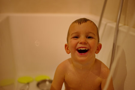 Cute little toddler having shower in bathtubの写真素材