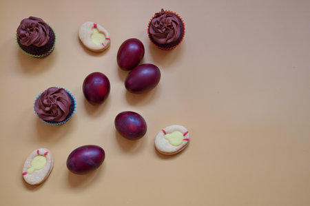 Painted Easter eggs and cookies against yellow background