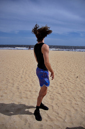 Young handsome man standing on a sandy beachの写真素材
