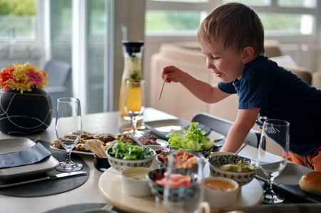 Little toddler at the table choosing dishの写真素材