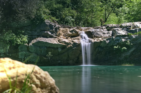 Long exposure of waterfall over a rocky cliff into a deep green pool of Mirna river in Croatiaの写真素材