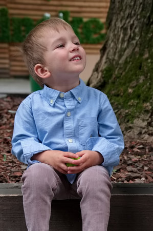 Portrait of toddler sitting under the tree