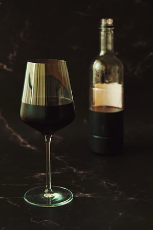 Glass of red wine and bottle on marble backgroundの写真素材
