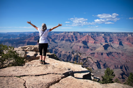 Rear view of mature woman standing on the rim of Grand Canyonの写真素材