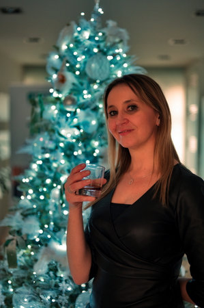 Mature woman standing in front of Christmas treeの写真素材