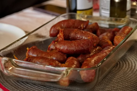 Closeup of sausages in the glass container on the tableの写真素材