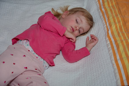 Portrait of cute little girl sleeping in bedの写真素材