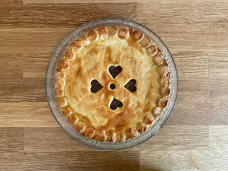 Whole homemade baked to a crisp apple pie, top view, decorated with hearth symbols. High quality...