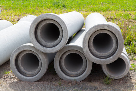 five sewer pipes made of concrete lying in the sandの写真素材