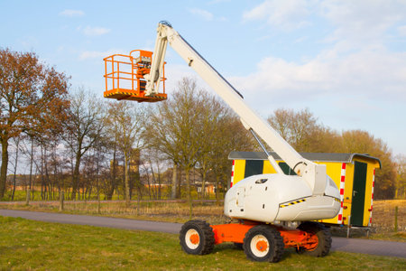 an aerial platform for pruning trees with the sky as background