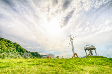 White wind turbine generating electricity around sea.の写真素材