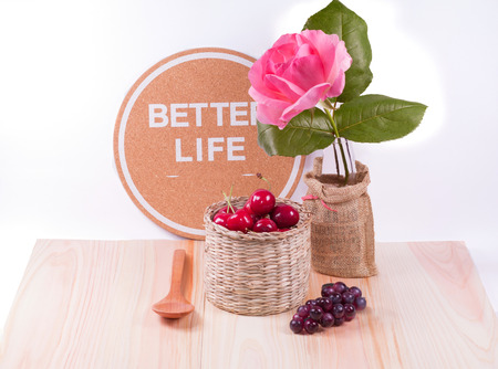 Cherries and  wooden spoon  with dark grapes , inspiration words , flower and white background.の写真素材