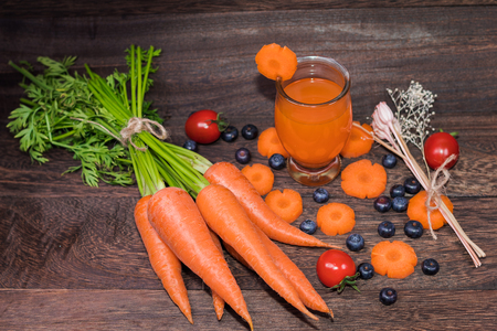 Healthy eating and dieting concept,fresh carrot  and carrot juice or organic healthy juice in glass , tomato ,fruit,vegetables on a grey wooden table wall background with copy space .の写真素材