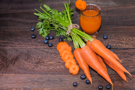 Healthy eating and dieting concept,fresh carrot  and carrot juice or organic healthy juice in glass,fruit,vegetables on a grey wooden table wall background with copy space .の写真素材