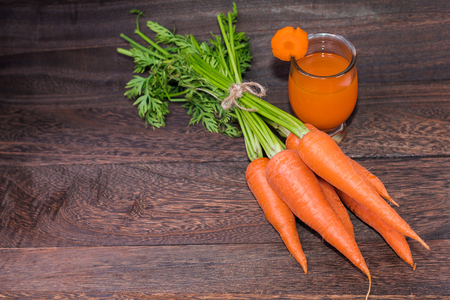 Healthy eating and dieting concept,fresh carrot  and carrot juice or organic healthy juice in glass on a grey wooden table wall background with copy space .の写真素材