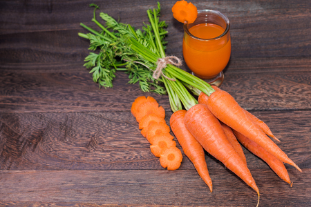 Healthy eating and dieting concept,fresh carrot  and carrot juice or organic healthy juice in glass on a grey wooden table wall background with copy space .の写真素材