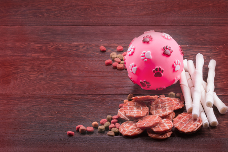 Ball toy for dog and dog snack ,dog Food, dog Chews, dog biscuits on a grey wooden table wall background with copy space .の写真素材