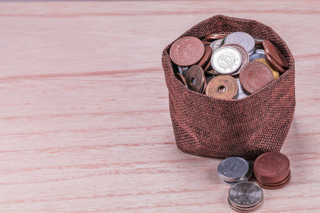 Japanese coins in sackcloth on  wooden  wall background .の写真素材