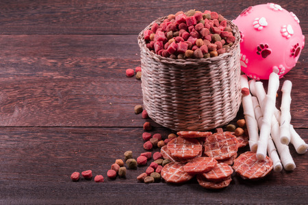 Dog snack ,dog dood, dog chews, dog biscuits,ball toy for dog on a grey wooden table wall background with copy space .の写真素材