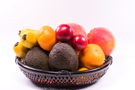 Fresh organic fruits in wicker basket on white background.の写真素材