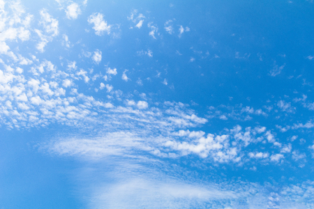 Clear blue sky background with white clouds.の写真素材