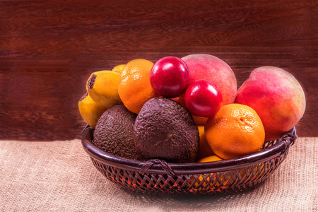 Fresh organic fruits in wicker basket on a grey wooden table wall background with copy space .の写真素材