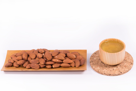Hot green tea and  Delicious almond nuts on white background  with clipping path.の写真素材